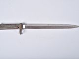 an old knife that is laying on a white surface