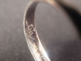 a close up of a silver ring with a diamond on it