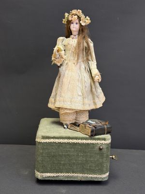 une vieille poupée est posée sur une valise