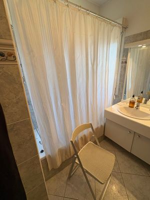 Un rideau et une chaise de douche pliante ajourée nid d'abei…