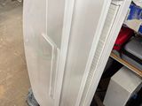 a white refrigerator sitting in a garage next to a pile of boxes