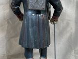 a statue of a man wearing a hat and holding a cane