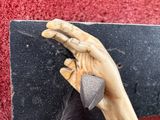 a statue of a hand holding a skateboard on a wall