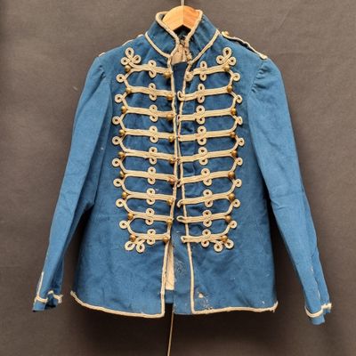 une vieille veste militaire bleue accrochée à un cintre au mur