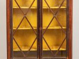 une bibliothèque en bois avec deux portes vitrées et deux étagères