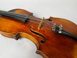 an old violin sitting on top of a white table next to a white wall