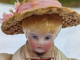 a doll that is wearing a hat and a coat