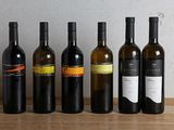 plusieurs bouteilles de vin sont alignées sur une table en bois