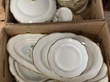 plusieurs assiettes et bols dans une boîte posée sur le sol