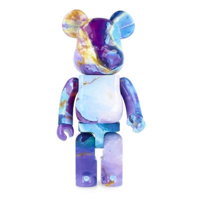 a purple and blue bear with a white shirt on