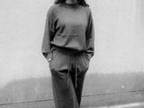 black and white photograph of a woman standing on a brick sidewalk