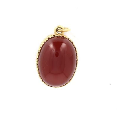 un gros plan d'un pendentif en pierre rouge sur fond blanc