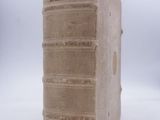 an old book sitting on top of a table with a white background