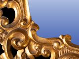 a mirror that has a gold frame on it