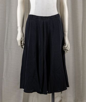 a mannequin wearing a white top and black skirt
