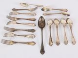 many spoons and forks laid out on a table