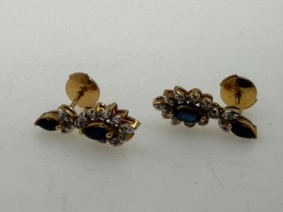 two pairs of earrings with blue stones on them