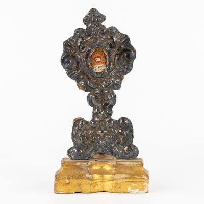 an image of a clock on a wooden stand with a crown on it