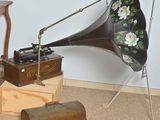 un vieux gramophone posé par terre à côté d'autres objets anciens
