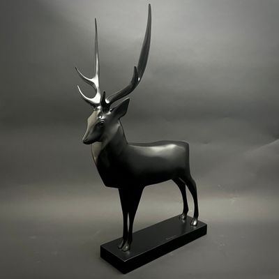 statue d'un cerf avec des bois, posée sur un socle noir