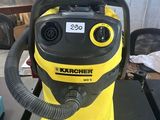 un aspirateur jaune et noir posé sur une table noire