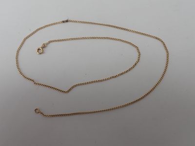 a close up of a gold chain on a white surface