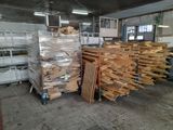several stacks of wood sit in a warehouse with pallets of wood