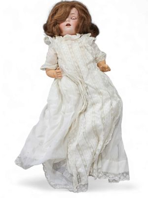 an antique porcelain doll of a woman in a white dress
