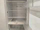 a white refrigerator with its door open in a kitchen
