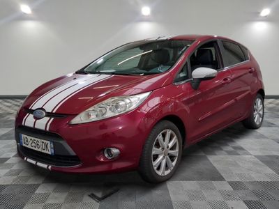 La Ford Fiesta rouge est garée sur un sol en carrelage à damier.