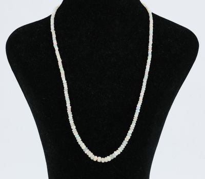 un collier de perles blanches autour du cou d'un mannequin noir