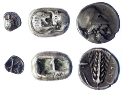 several silver coins with faces and ears on them on a white surface
