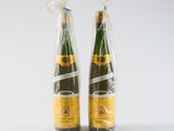 two bottles of champagne wrapped in plastic bags on a white surface