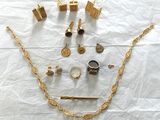 beaucoup de bijoux en or posés sur un drap blanc