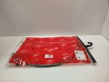 the red bag is sitting on a white surface