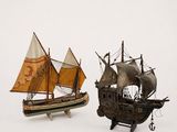 two model ships that are sitting side by side on a white surface