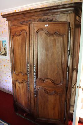 une grande armoire en bois dans le coin d'une pièce