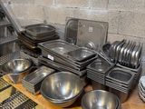 de nombreuses casseroles et poêles posées sur une table dans une cuisine