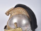 pair of silver and gold helmets with black hair on a white surface
