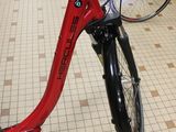 a red scooter that is parked next to a bunch of bikes