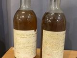 two bottles of wine sitting on top of a wooden table