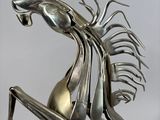 a metal sculpture of a horse that is sitting on it ' s back legs