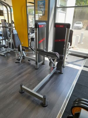une salle de sport avec une rangée de machines