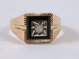 an image of a gold ring with a black and white diamond