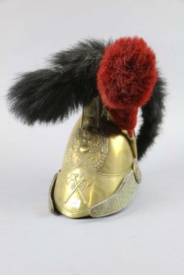 a gold shoe with a red pom pom on top of it