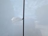the side of a white car with a hole in the side of it