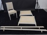two chairs and a table in front of a black backdrop