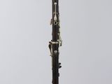 a black and gold clarinet sitting on top of a clear stand
