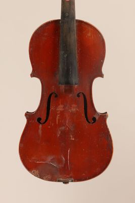 an old violin sitting on top of a white surface