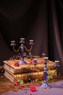 three candles that are sitting on a table with books